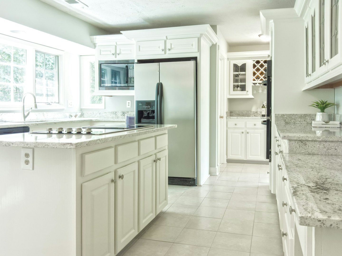 Cucina moderna con mobili bianchi e elettrodomestici in acciaio inossidabile.